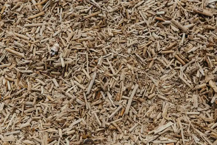 Close-up view of a textured surface of natural brown wood chips, ideal for organic and environmental themes.